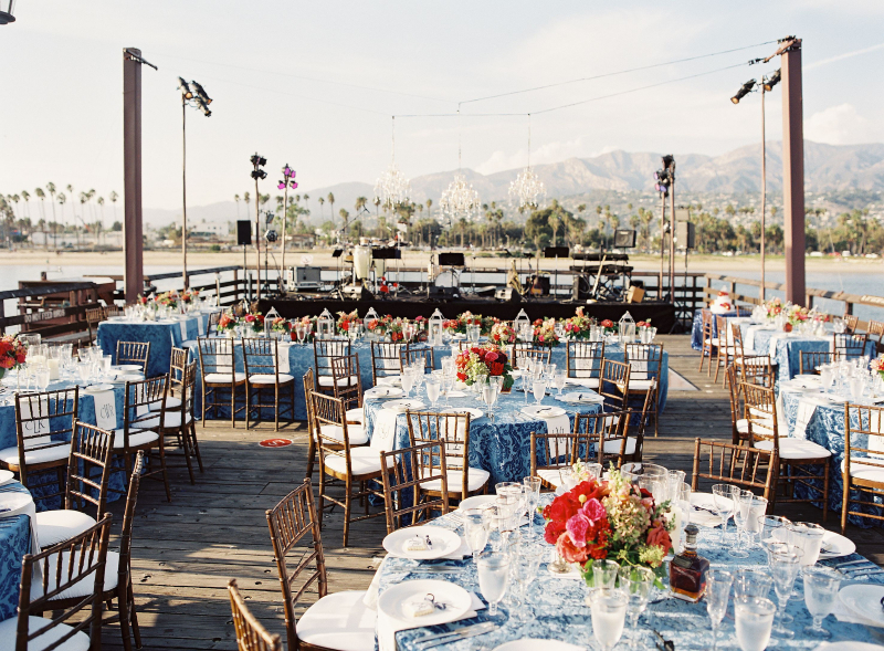 dining tables with festive place settings set up on Stearns Wharf looking back towards the coast and mountains