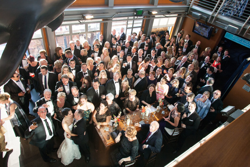 Merry revelers in formal dress raise a glass in the lobby of the Sea Center